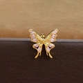 Detailed close-up of a golden butterfly ear stud with pink stones and a ball back screw - Gold Pink Zirconia