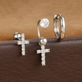 Détail macro de boucles d'oreilles croix argentées avec zircons sur un présentoir - Forme de Croix - Argent