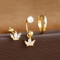Dettaglio di orecchini dorati con corona di zirconi e set di cerchi minimalisti - Design corona-Oro
