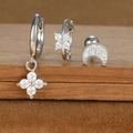 Macro shot of a three-piece jewelry set featuring star, moon, and flower zircon earrings - Four-petaled Flower and Moon Style (E1610-8) / Silver