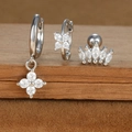Macro detail of silver-plated star and moon earrings with zirconia on a brown velvet surface - Four-petaled Flower and Crown Style (E1610-10) / Silver