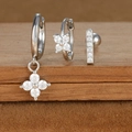 Macro detail of silver zircon earrings set featuring star and moon geometric shapes - Silver