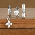 Macro detail of three-piece silver earring set with zircons on wooden display - Four-leaf Flower and Rectangular Zirconia Style (E1610-17) / Silver