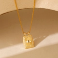 Détail du pendentif tarot œil protecteur doré avec cristaux et émail sur surface de pierre - Mauvais Œil Doré