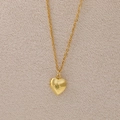 Golden heart locket necklace with sunburst engraving and tiny yellow birthstone - August