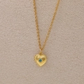 Golden heart locket necklace with sky blue birthstone and radiant starburst engraving - December
