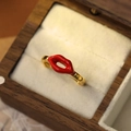 Vue macro d'une bague dorée avec motif lèvres en émail rouge dans un coffret en bois - Or 18K-Grandes Lèvres Rouges