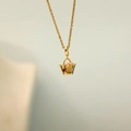 Macro detail of a gold basket necklace with red heart stone and BUY text engraving - Gold Butterfly Bag Necklace