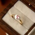 Gros plan sur bague cœur dorée avec zircon rose et sertissage en émail blanc - Or 16K-Petit Cœur Rose