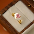 Détail d'une bague ajustable dorée avec cœur en zircon rose et émail blanc incrusté - Or 18K-Grand Cœur Rose