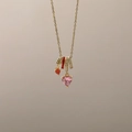 Nahaufnahme von herzförmigem rosa Kristall und Sternanhänger an goldener Kette - Rosa Herz Zirkon