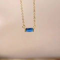Minimalist gold necklace with a horizontal rectangular dark blue birthstone pendant - September