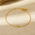 Détail d'un bracelet doré avec deux pierres de naissance sur une surface en pierre - Mars