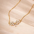 Elegant gold flower necklace featuring white opal petals and sparkling zircon accents - Gold