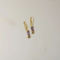 Detailed view of gold hoop earrings featuring elegant rectangular purple gemstones - February