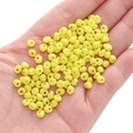 Hand holding bright yellow 5mm glass seed beads for DIY handmade jewelry crafts - Yellow Approximately 5x5mm Pore Size Approximately 1mm 10g/pack Approximately 100 Pieces.