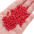 Hand holding 5mm vibrant red glass seed beads with glossy finish for DIY jewelry making - Red Approximately 5x5mm Pore Size Approximately 1mm 10g/pack Approximately 100 Pieces.