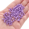5mm light purple glass seed beads in palm showing small size for DIY jewelry - Crystal Purple Approx. 5x5mm Aperture Approx. 1mm 10g/pack Approx. 100 Pieces
