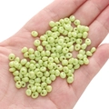 Handheld view of 5mm light green glass seed beads for DIY jewelry making and crafts - Grass Green Approximately 5x5mm Pore Size Approximately 1mm 10g/pack Approximately 100 Capsules