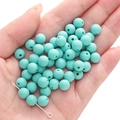 Matte tiffany blue acrylic beads for DIY jewelry making held in a person's palm - Malachite green