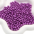 Polished dark purple ABS imitation pearls in a white ceramic dish for DIY crafts - Deep purple