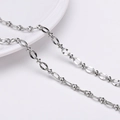 Silberne Edelstahlkette mit geometrischen Gliedern auf einem weißen Keramikteller - Lippe Figur 8 Polierte Kette (FLB075) / 1 Meter/Packung