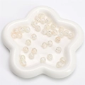 Translucent crackle glass beads with aurora finish in a white petal ceramic tray - Beige