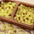 DIY yellow pumpkin-shaped jade glass beads for handmade jewelry on a wooden tray - Yellow Flat Pumpkin Bead