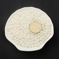 Glossy white ABS imitation pearls for DIY jewelry making displayed in a ceramic dish - 8mm 130 Pcs/Pack (With Hole) / White