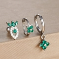 Close-up of three clover earrings with green emerald zircons on brushed metallic surface - Silver-Green (Y26109-10)