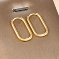 Macro detail of gold-plated horseshoe hoop earrings with secure click-lock closure clasp - Oval Hoop / Gold Style (E1295-7)