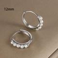Dettaglio di orecchini a cerchio argento da 12 mm con cinque perle bianche incastonate - 12mm / Argento (Y20397)