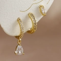 Primer plano de set de pendientes de oro 18K con circonitas en forma de gota de agua - Oro-Blanco