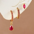 Primer plano de pendientes bañados en oro con dijes y tachuelas de circón rojo - Dorado - Rosa rojo
