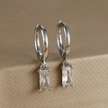 Macro detail of square-cut zircon earrings with polished silver finish on a gold stand - Rectangular Gemstone Hoop (Y20278) / Silver-White