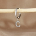 Macro detail of silver hoop earring with crystal pavé letter C pendant on wood support - 1 Piece / Silver-Letter C