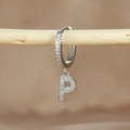 Macro detail of silver huggie hoop earring with crystal pavé letter P pendant on wood - 1 Piece / Silver-Letter P