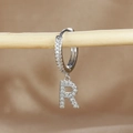 Macro shot of silver letter R hoop earring with micro-pave cubic zirconia on wood stand - 1 Piece / Silver-Letter R