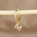 Macro detail of gold hoop earring with letter M pendant and micro-pave zircons - 1 Piece / Gold - Letter M
