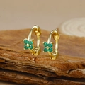 Detail of clover earrings with green zircon stones on natural wood bark texture - Gold Four-petal Flower Green Zircon Hoop Earrings (Y20309)