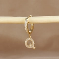 Detail of gold-plated letter Q earring with micro-pave zircons on a wooden stand - 1 Piece / Gold - Letter Q