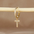 Macro detail of gold T letter earring with micro-paved cubic zirconia on a wooden display - 1 Piece / Gold - Letter T