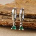 Macro shot of silver-plated hoop earrings with round green zircon charms on textured wood - Silver Round Green Zircon Pendant Hoop Earrings (Y20301)