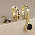 Macro shot of three-piece gold stud and hoop earring set with black zircon stones - Gold-Black