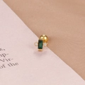 Dettaglio ravvicinato di un orecchino a perno dorato con zircone verde rettangolare - Stile Gemma Verde Rettangolare (E1357-3) / Oro