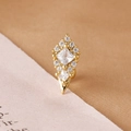 Macro shot of gold-plated stud earring with square zircon stones and a sharp cone drop - Shield Rhombus / Gold