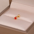 Vue macro d'un clou d'oreille en acier doré avec zircon rouge et fermoir à vis - Red Zirconia Ear Bone Stud / Or Rouge