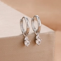Detail view of silver hoop earrings with two dangling clear zircons on a texture background - Silver Tiered Double Stone Drop Style (Y26820)