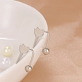 Minimalist silver heart-shaped U-shaped stud earrings on a white ceramic bowl edge - Silver Heart