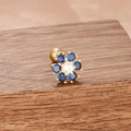 Gros plan d'une boucle d'oreille fleur dorée avec gemmes bleues et fermoir à boule - Style de Fleur à Six Pétales en Pierre Bleu Foncé (E1171-Or Bleu Foncé)